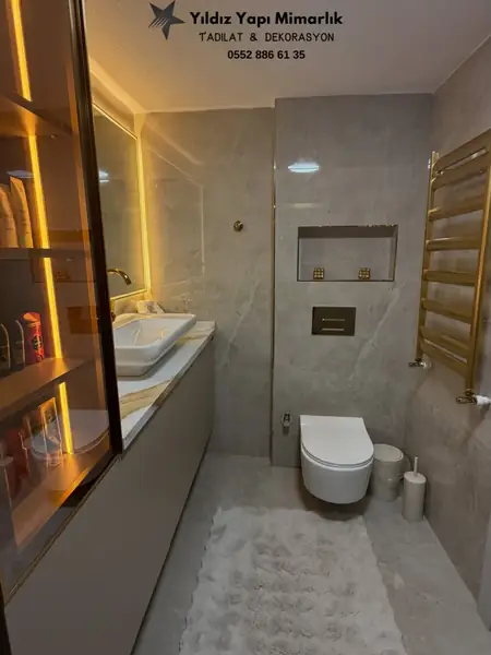 Modern banyo tadilatı genel görünüm, asma klozet ve gold havlupan
